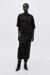 Buzo boxy de punto jacquard suave, con estampado de leopardo en tonos marrón oscuro y negro. Presenta cuello redondo acanalado, hombros caídos y mangas al codo.