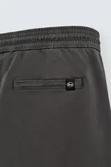 Pantalón jogger negro de corte slim fit, confeccionado en tejido de algodón con cintura elástica ajustable con cordón, bolsillos frontales y traseros de vivo, y bajo con puño elástico.