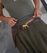 Cinturón marrón de cuero con hebilla dorada en forma de caballo.