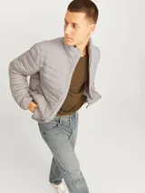 Campera puffer gris de manga larga con cuello alto y cierre frontal con cremallera.