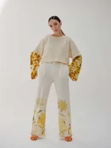 Buzo color crudo con mangas largas acampanadas con estampado floral en tonos amarillos y marrones.