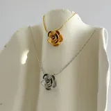 Collar dorado con dije en forma de rosa.