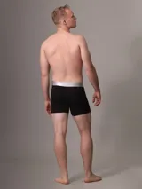 Pack de tres bóxer brief negros de algodón con cintura elástica plateada con el logo de Calvin Klein.