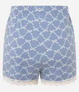 Conjunto de pijama celeste con estampado de lazos blancos, compuesto por una remera de mangas cortas y un short con cintura elástica y detalle de encaje en el ruedo.