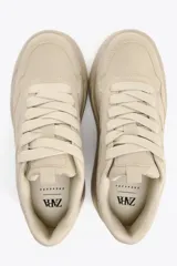 Zapatillas deportivas color beige con plataforma alta. Cierre con cordones.