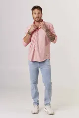 Camisa de hombre color crema, de corte clásico, con cuello abotonado y mangas largas.