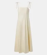 Vestido midi color amarillo pálido, con escote recto y busto con recortes. Posee breteles finos ajustables con lazo y cierre trasero de cremallera.