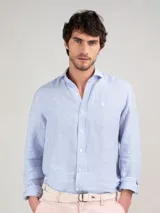 Camisa celeste a rayas verticales de lino, corte regular fit, cuello italiano, cierre con botones, manga larga terminada en puño simple y logo bordado en el pecho.