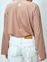 Remera manga larga color rosa pálido, de corte holgado y cuello redondo.