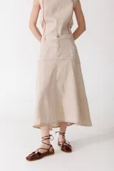 Falda midi color beige de corte acampanado, con bolsillos delanteros y costuras a la vista.
