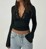 Top negro de mangas largas con escote en V y detalles de encaje.