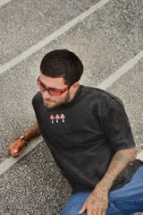 Remera color arena de algodón con cuello redondo y mangas cortas. Estampado frontal con tres hongos rojos y la palabra "Tuya" debajo.