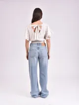 Blusa corta a rayas horizontales color beige y blanco, con mangas cortas con volados y elástico en la cintura.