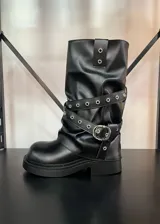 Botas de caña media color negro, con suela track y correas con hebilla plateada alrededor de la caña. El material es símil cuero.