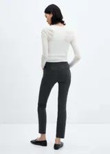 Pantalón de vestir gris oscuro, de corte skinny, tiro medio, con bolsillos laterales y traseros.