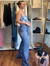 Pantalón oxford de bengalina azul con cintura alta y corte ajustado hasta la rodilla, luego se ensancha hasta el ruedo.