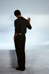Camisa negra de corte estándar, con cuello mao, tapeta clásica y mangas largas con puños abotonados.