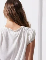Remera negra de modal con escote en V y aplique de puntilla en mangas y escote. Detalle fruncido en hombros.