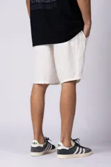 Bermudas color beige de lino, con cintura elástica y bolsillos laterales.