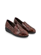 Zapato mocasín de cuero sintético color negro con textura símil cocodrilo.