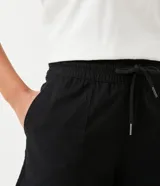 Short runner naranja de lyocell con cintura elástica ajustable con cordón y bolsillos laterales.