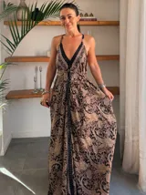 Vestido largo tipo solera, color turquesa con estampado paisley en tonos marrones y dorados. Diseño con escote halter anudado al cuello y abertura frontal central en color liso.