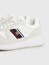 Zapatillas Tommy Hilfiger blancas con detalles en gamuza y la cinta distintiva de la marca en el lateral.