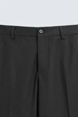 Pantalón de vestir gris oscuro, corte slim fit, con bolsillos laterales y traseros de ojal. Cierre frontal con cremallera y botón.