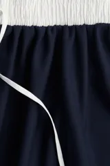 Minifalda azul marino con cintura elástica blanca y cordón ajustable.
