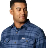 Camisa de franela Columbia para hombre, a cuadros en tonos negro, gris, beige y blanco. Confeccionada en algodón con elastano para mayor comodidad y flexibilidad. Cuenta con cuello abotonado, cierre frontal con botones, dos bolsillos en el pecho con cierre de botón y puños abotonados.