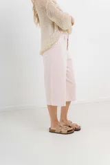 Bermuda de tiro medio color crema, con corte recto y largo a la rodilla. Diseño amplio tipo culotte corto, con dobladillo ancho en el ruedo. Presenta bolsillos delanteros y traseros funcionales.