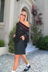 Sweater calado negro con cuello desbocado y mangas largas.