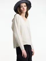 Sweater de punto color crema con escote en V y mangas largas.