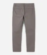 Pantalón de vestir marrón, de corte skinny, con bolsillos laterales y traseros. Se ajusta a la cintura con cinturón de cuero marrón.