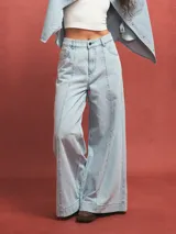 Pantalón de jean celeste de corte acampanado con costuras verticales en el frente.