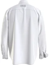 Camisa blanca de algodón con corte relaxed, manga larga, bolsillo en el pecho y logo de Calvin Klein Jeans estampado verticalmente en el frente.