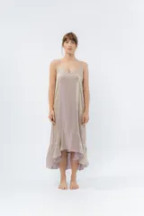 Vestido midi color lila metálico de breteles finos regulables, escote en V y ruedo asimétrico con leve vuelo.