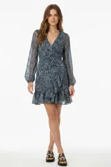 Vestido corto con estampado abstracto en tonos azules y blancos, escote en V cruzado, mangas largas abullonadas y falda con volantes.