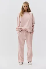 Buzo de tejido de punto color rosa pálido, con cuello redondo, hombros caídos y puños y bajo acanalados.