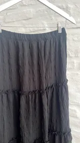Pollera larga de color negro con elástico en la cintura.