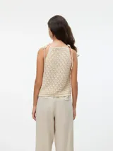 Top de punto color crema, con cuello halter y tiras finas para atar en el cuello.