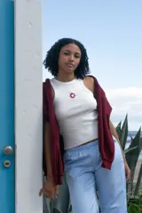 Musculosa blanca de algodón con cuello redondo y bordado de un sol rojo en el pecho.