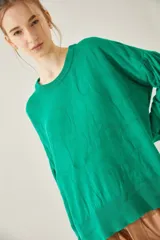 Sweater oversize de escote redondo en color verde, con diseño de margaritas y tajos laterales.