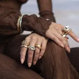 Brazalete rígido dorado con textura irregular.