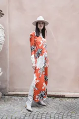 Vestido largo de seda color ladrillo con estampado de tigres, flores y palmeras. Tiene escote en V, mangas largas y tajos laterales.