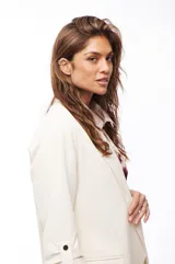 Blazer color crema con solapas de muesca, corte recto, bolsillos delanteros con solapa y mangas 3/4 con botón.