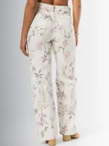 Pantalón wide leg de denim rígido con estampado floral chintz en tonos amarillo y rosa pastel sobre base blanca.