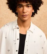 Camisa blanca de viscosa con estampado de cocoteros, corte relaxed, cuello inglés, manga corta y cierre abotonado.