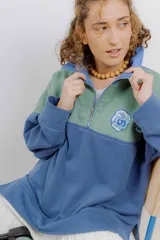 Buzo de algodón con cierre metálico y bordados de flores. Diseño color block en verde y azul.