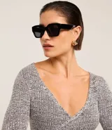 Blusa negra de punto acanalado, con escote en V profundo y mangas largas.